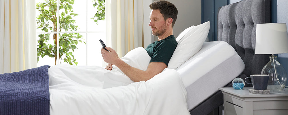 a man sat up in an adjustable bed