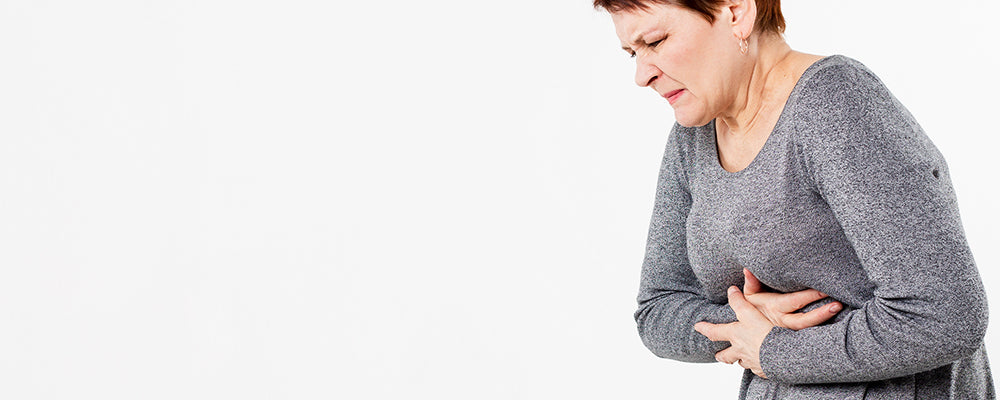 A woman holding her stomach with acid reflux