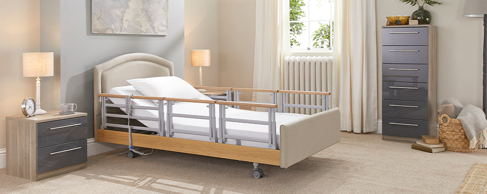 Profiling care bed in a liught bedroom with wooden rails either side of the bed