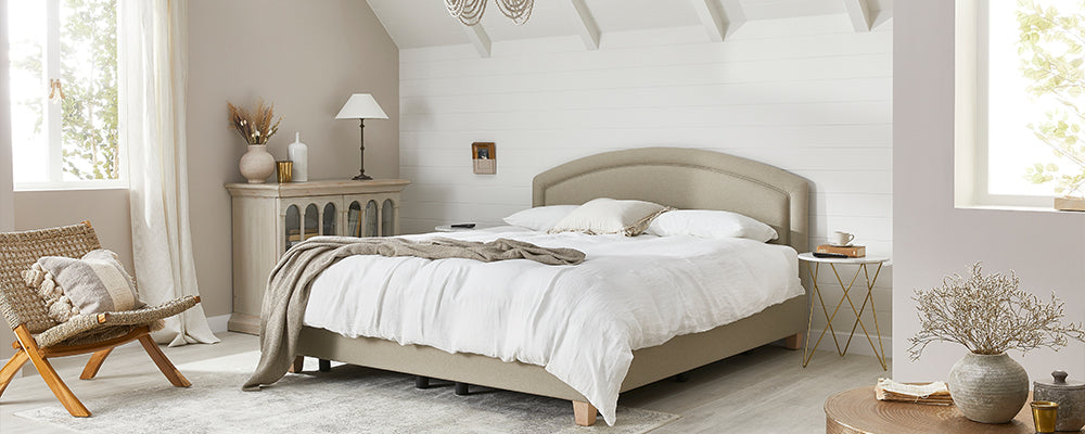 a light and homely bedroom with a linen bed and natural light