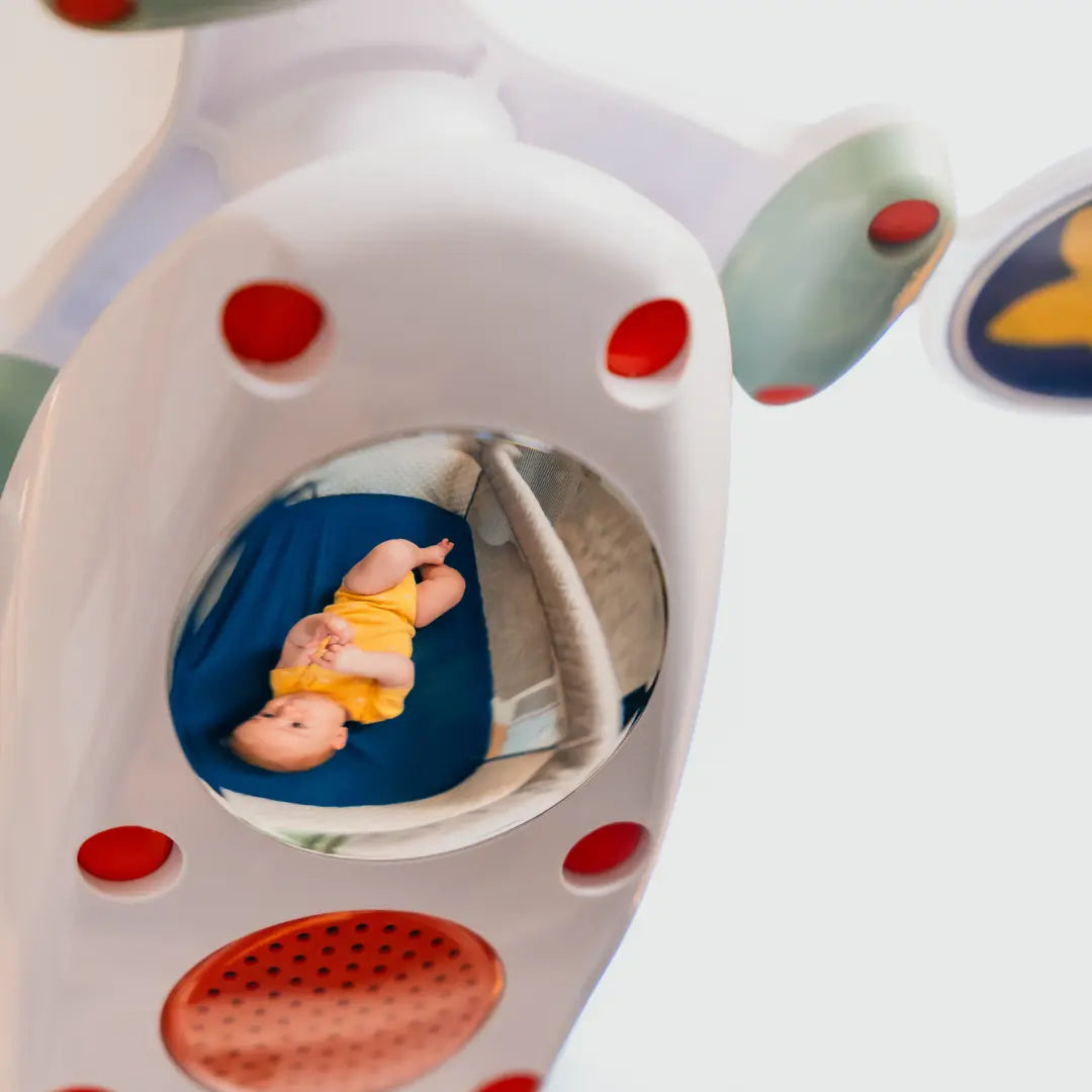 Baby's reflection in the domed mirror of the Multi-Fit Mobile.