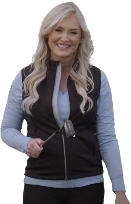 Smiling person holding a golf club on a grassy area.