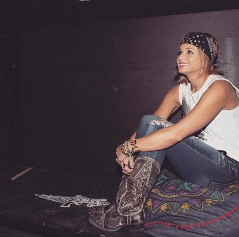 Miranda Lambert wearing ripped jeans, a white shirt and cowboy boots