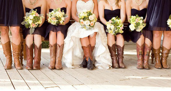 Bride with cowgirl boots with bridesmaids wearing cowboy boots all sitting down