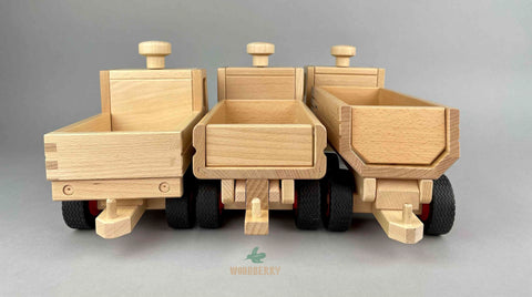 Fagus wooden toy. Truck comparison rear view. Left to right : unimog, dump truck, container tipper truck