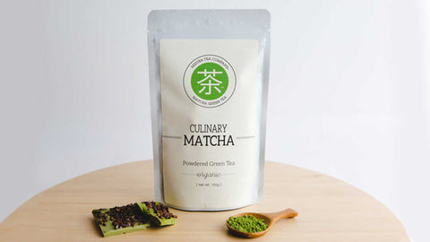 bag of mizuba culinary matcha with whisk and matcha candy bar pieces on table 