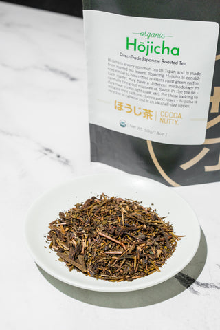 Plate of hojicha loose leaf Japanese tea on a table displayed with the Mizuba Tea Bag