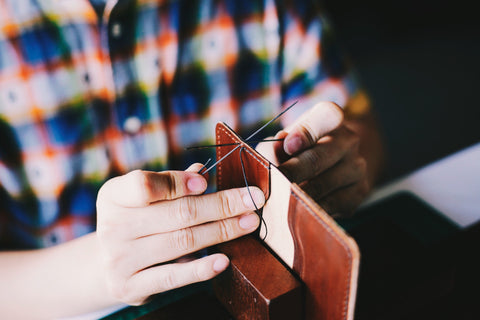 man sewing leather