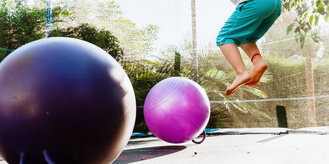 Boy jumping over balls on the trampoline