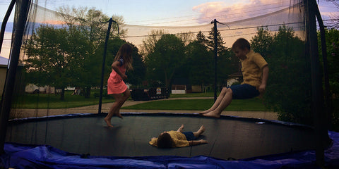 Children playing Dead Man game on trampoline