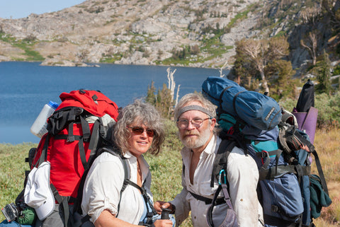 Conservation photographers Rob Badger and Nita Winter with backpacks in the Sierra Nevada Mountains in Carson Pass
