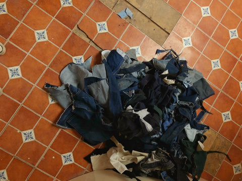 scrap denim remnants piled on top of a vintage tiled floor