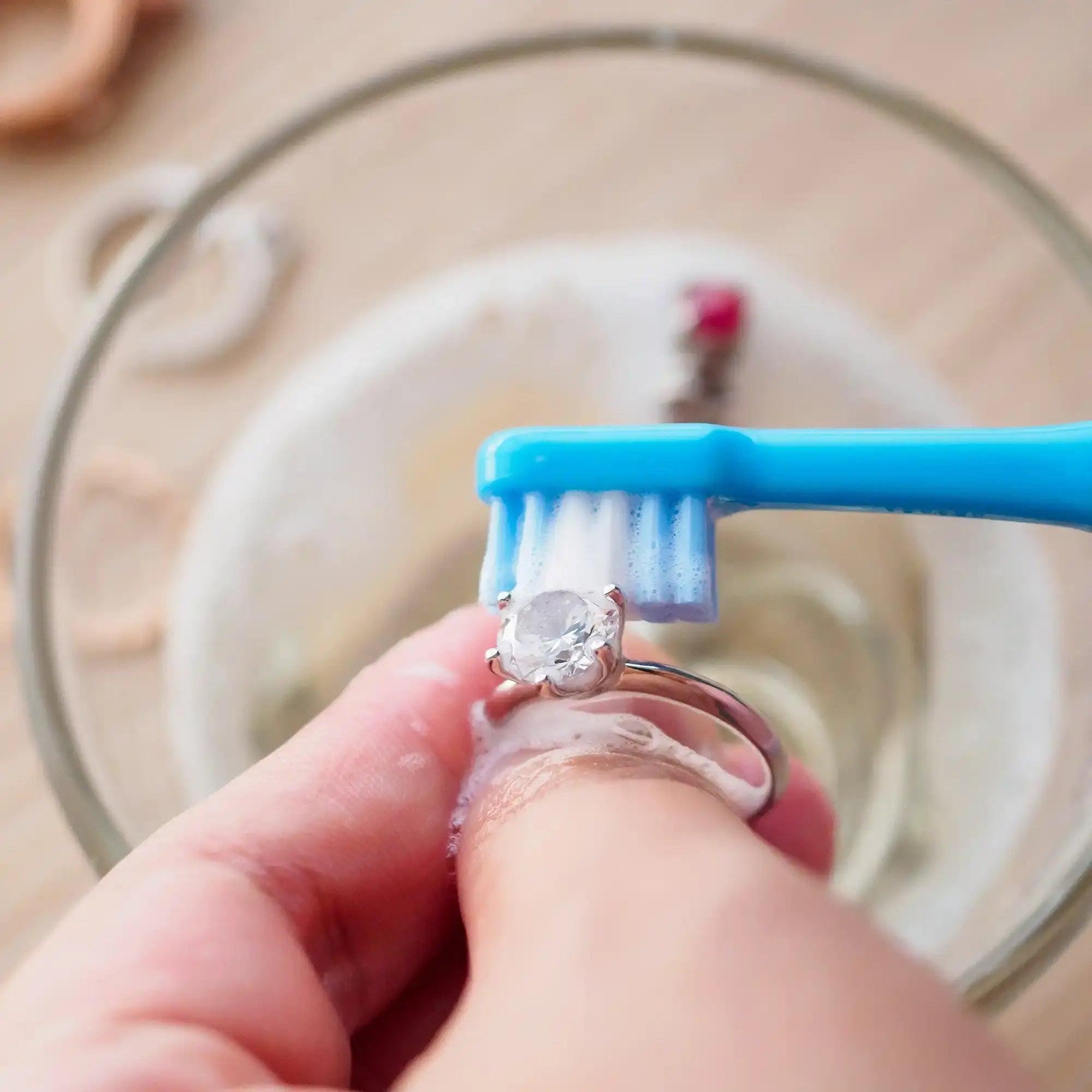 Diamond ring jewelry cleaning by soft bristle brush scrubbing and frequent gentle touching