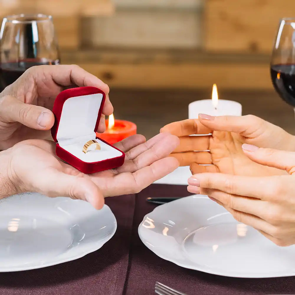 Man give the gold ring to his wife on a candlelight dinner