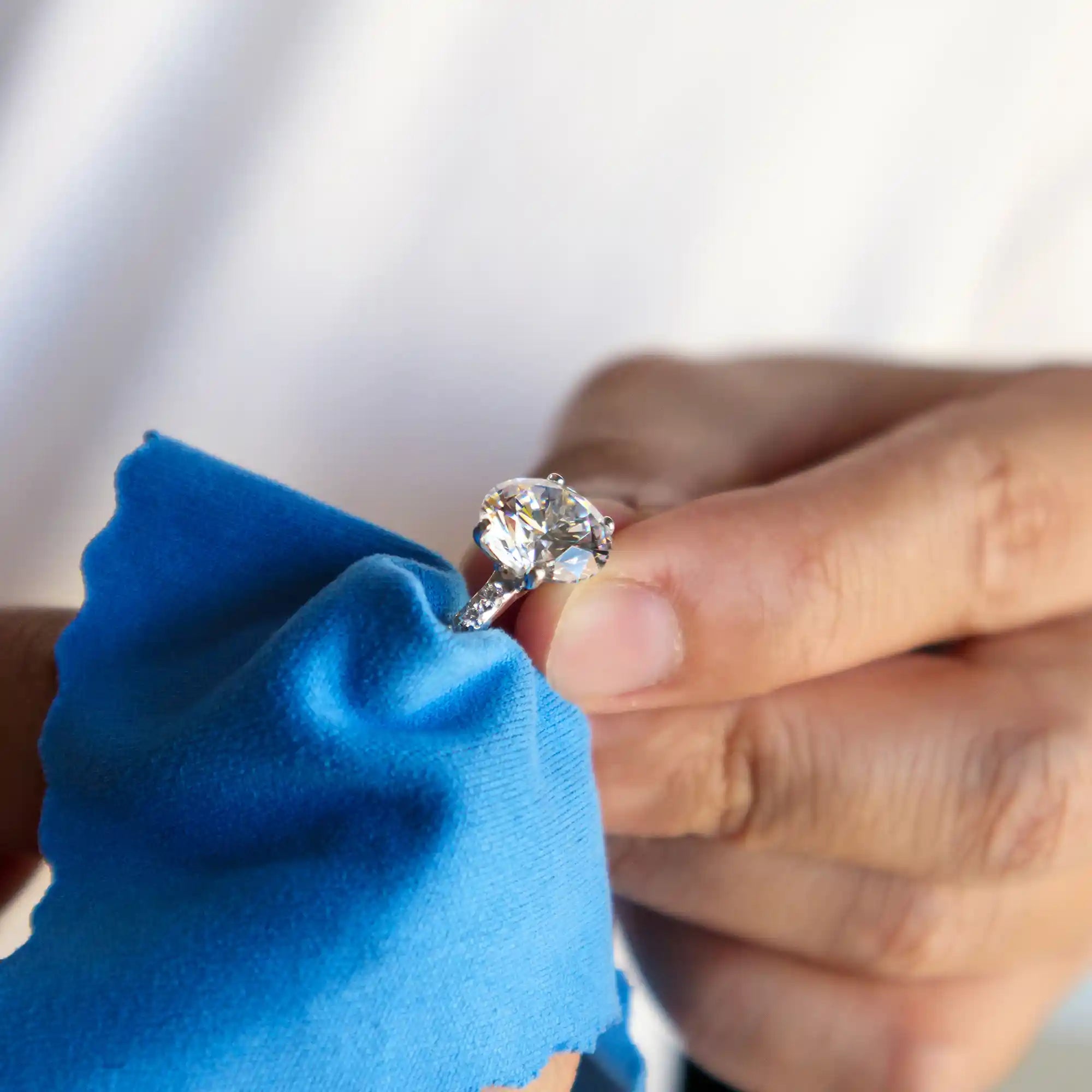 Soft cloth gentle scrubbing the diamond jewelry for a perfect cleaning and debris removing