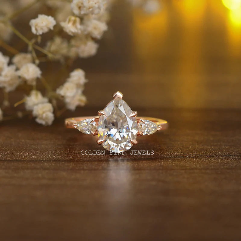 Colorless pear moissanite three-stone engagement ring in 14KT rose gold