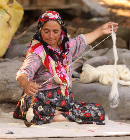 糸を紡ぐ女性の写真