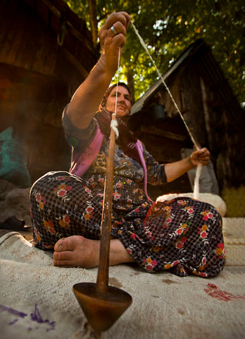 コマで糸を紡ぐ女性の写真