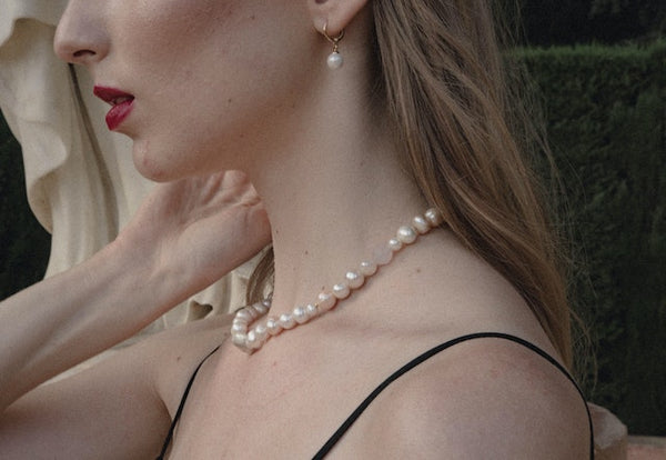 Mujer con aretes y collar de perlas 
