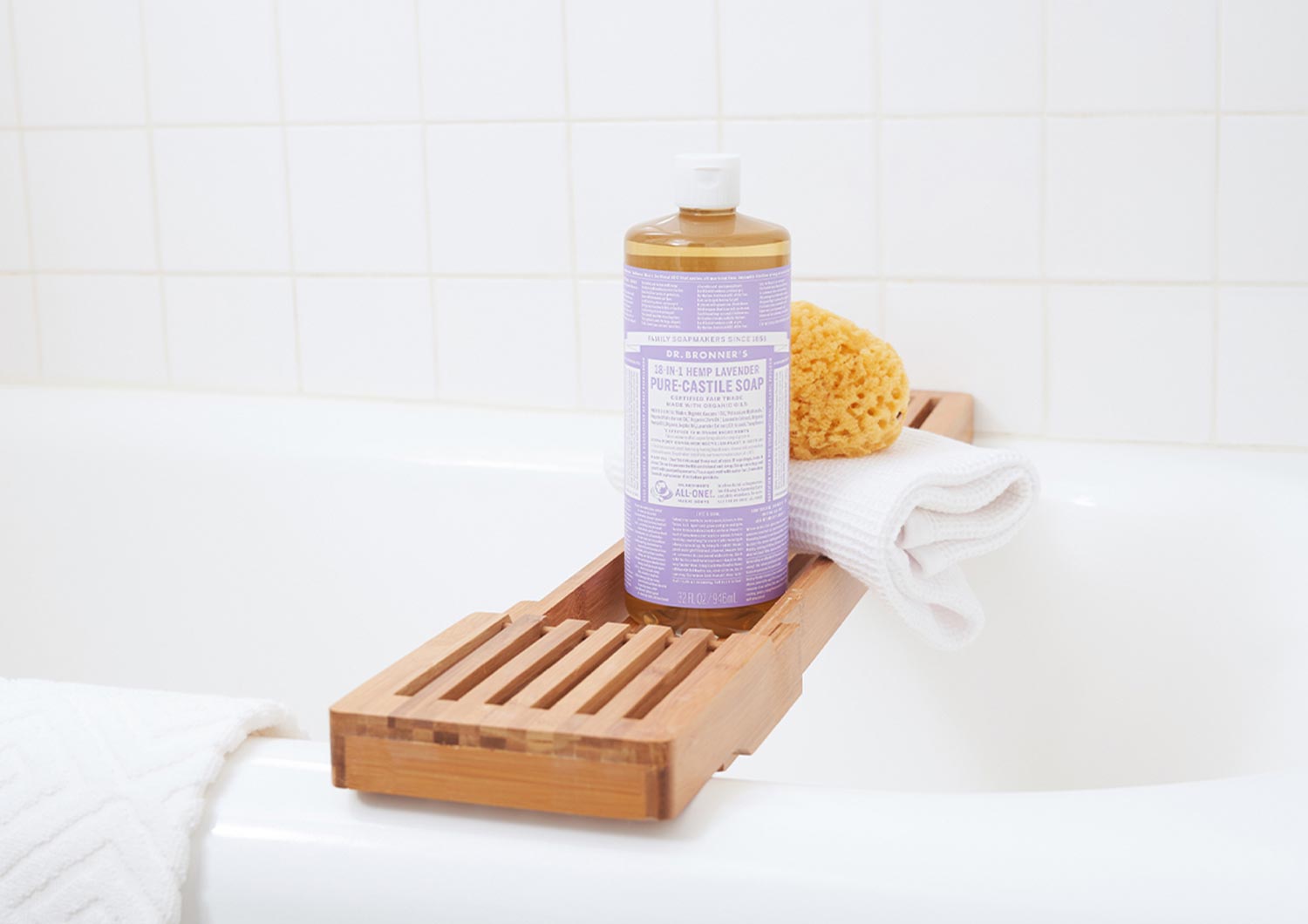 dr bronners lavender sustainable body wash on bamboo shelf over bathtub