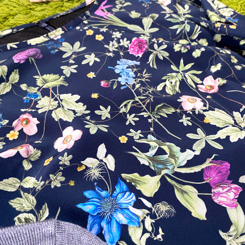 Dress with bright floral sleeves on a dark blue background