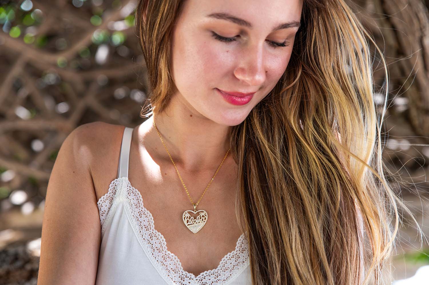 14K Gold vermeil heart pendant paved with white topaz gemstones and with aloha design inside the heart