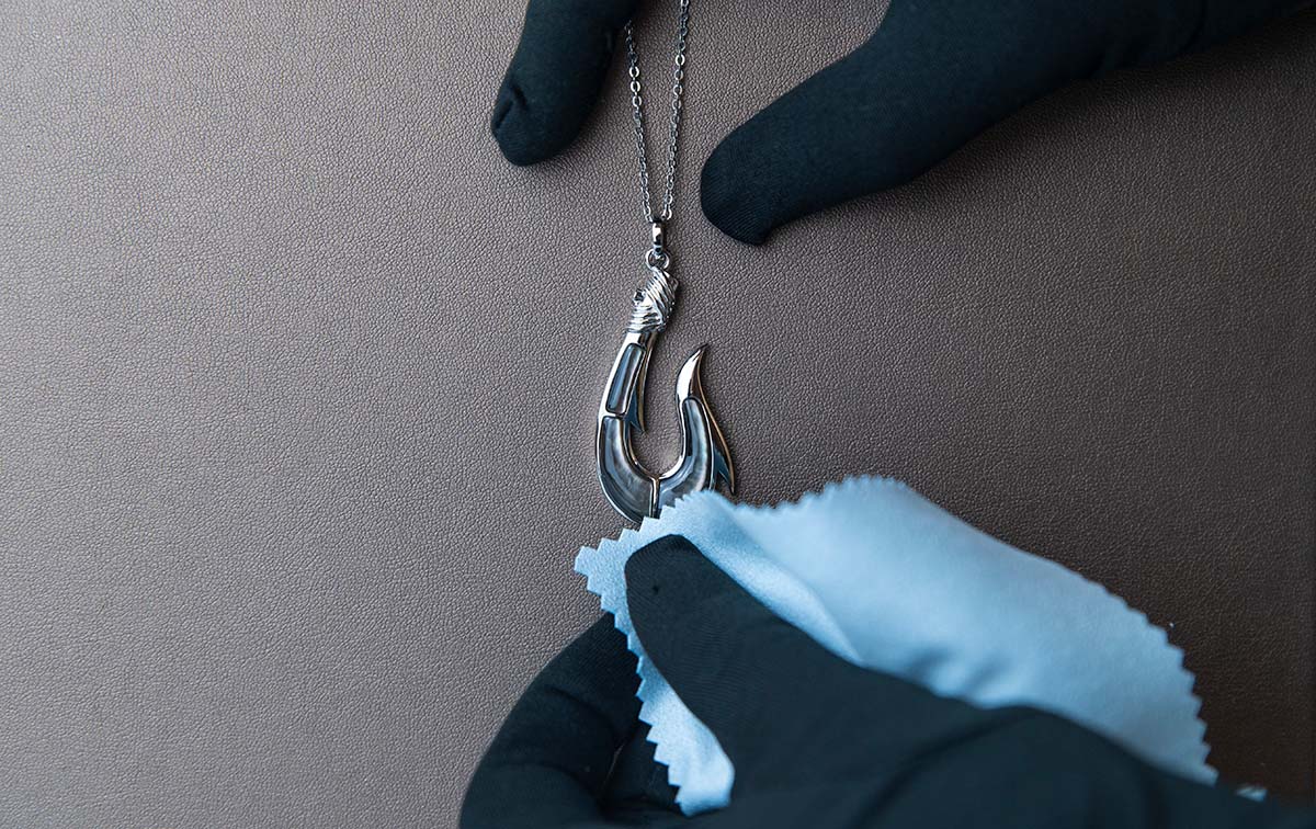 Abalone shell fishhook pendant being professionally cleaned