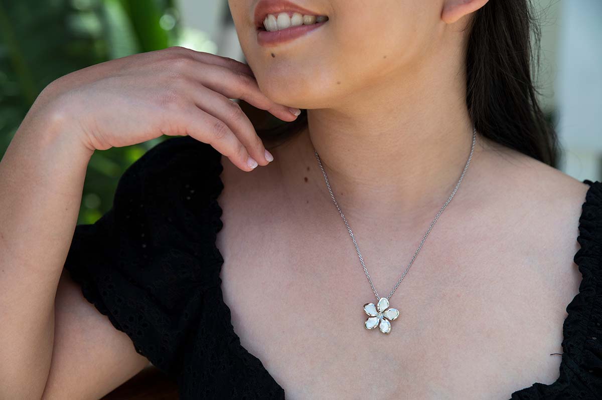 Mother of Pearl plumeria flower pendant worn by a model