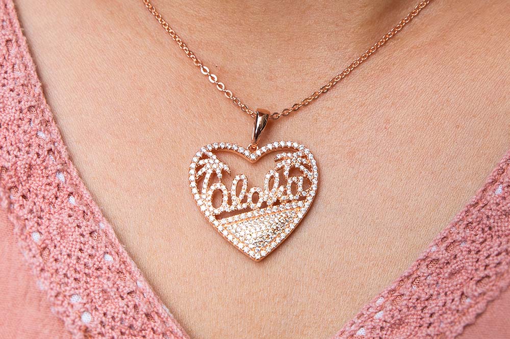 14k Rose gold aloha heart pendant features a heart motif with the Aloha lined with sparkling diamonds