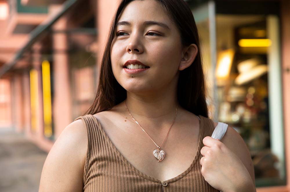 14K Rose Gold anthurium pendant lined with diamonds worn by a model