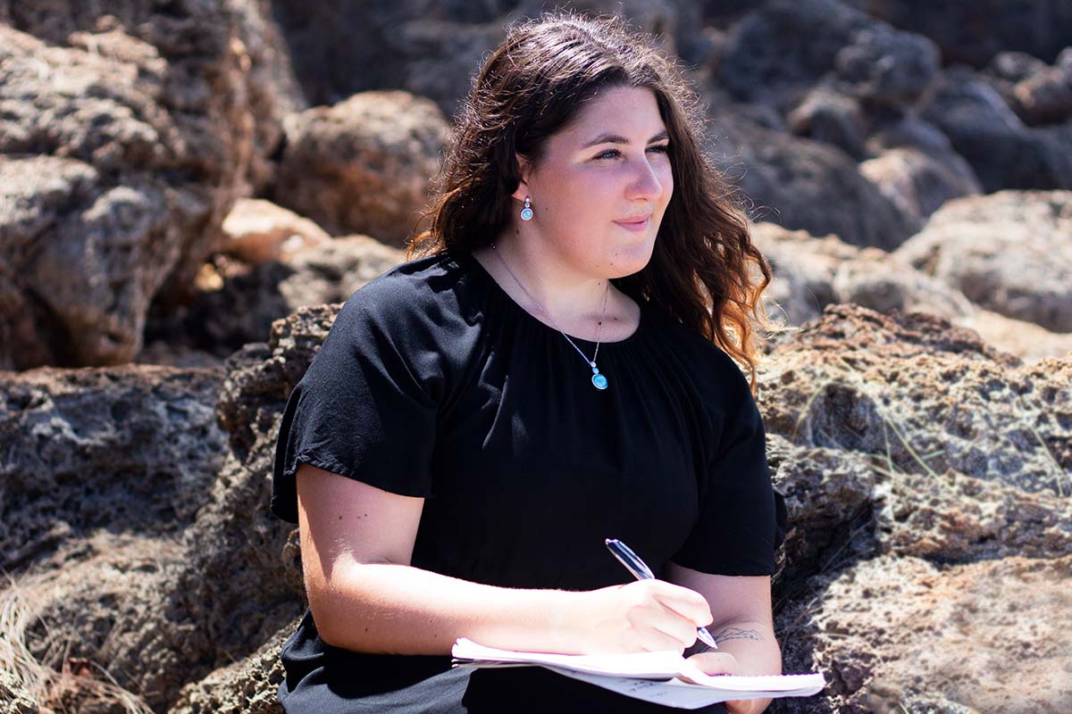 Helen Josephson on a beach writing a poem