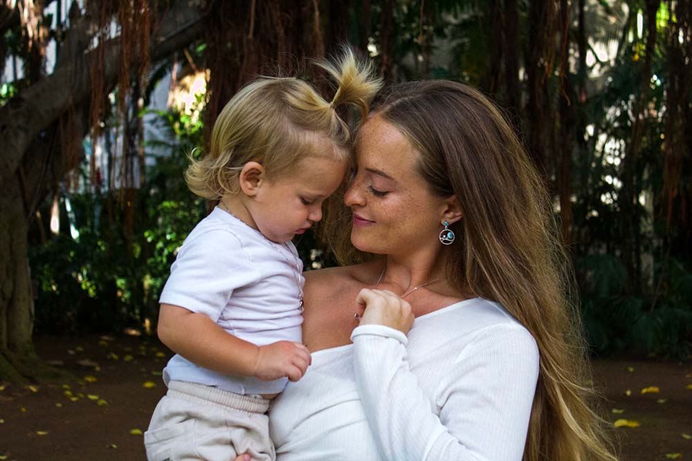 a young mom with her child featuring a Larimar Island earrings