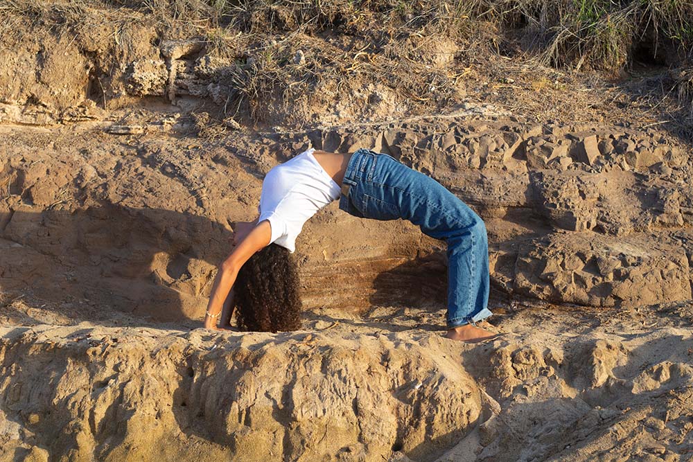 yoga instructor rae doing a "Wheel" yoga pose on the beach