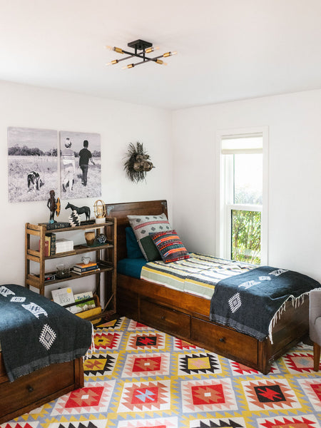 shared boys room with dark wood twin beds and vibrant colored textiles