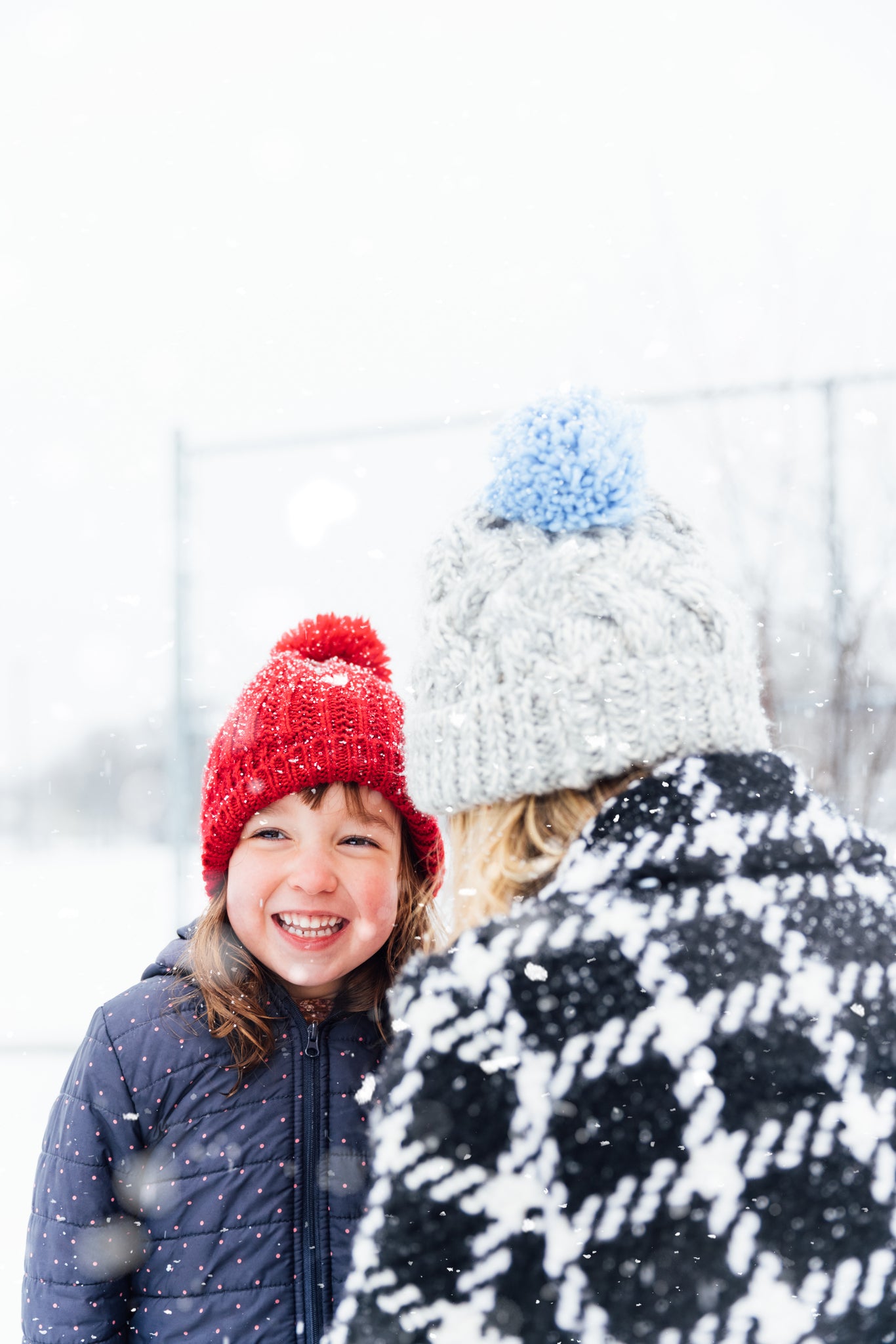 snow day kids activities girl in red beanie and navy blue coat in the snow