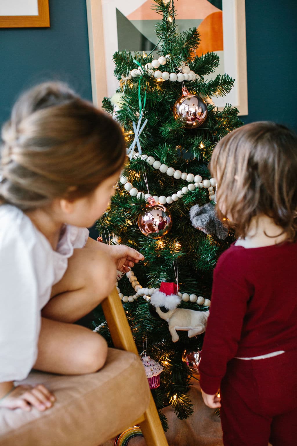 kids in nightgown and pajamas looking at small christmas tree