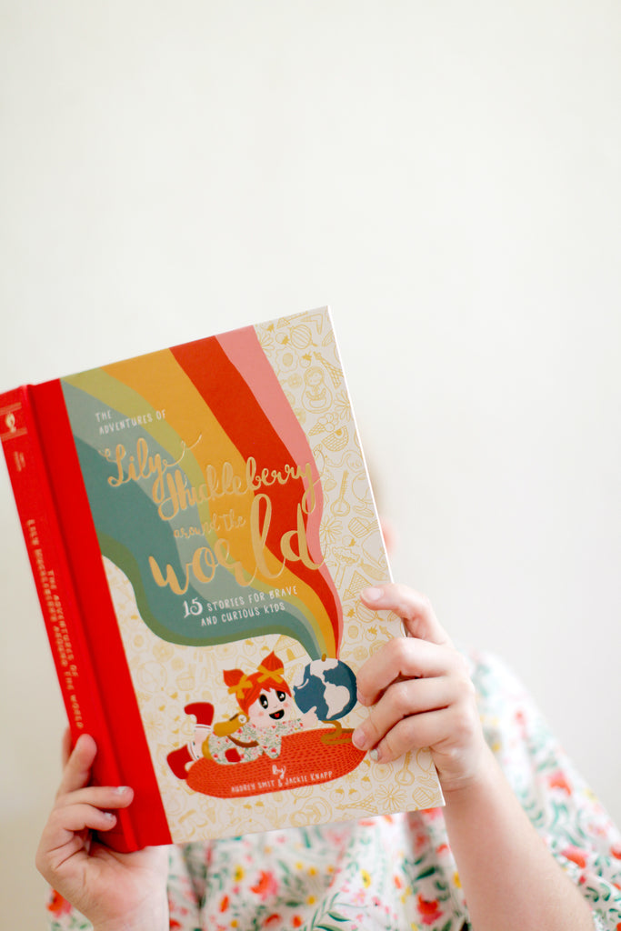 cover of children's book being held by child. books is covering child's face