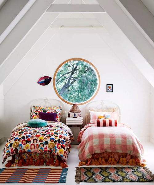 twin colorful beds in a shared space with many different colors and patterns