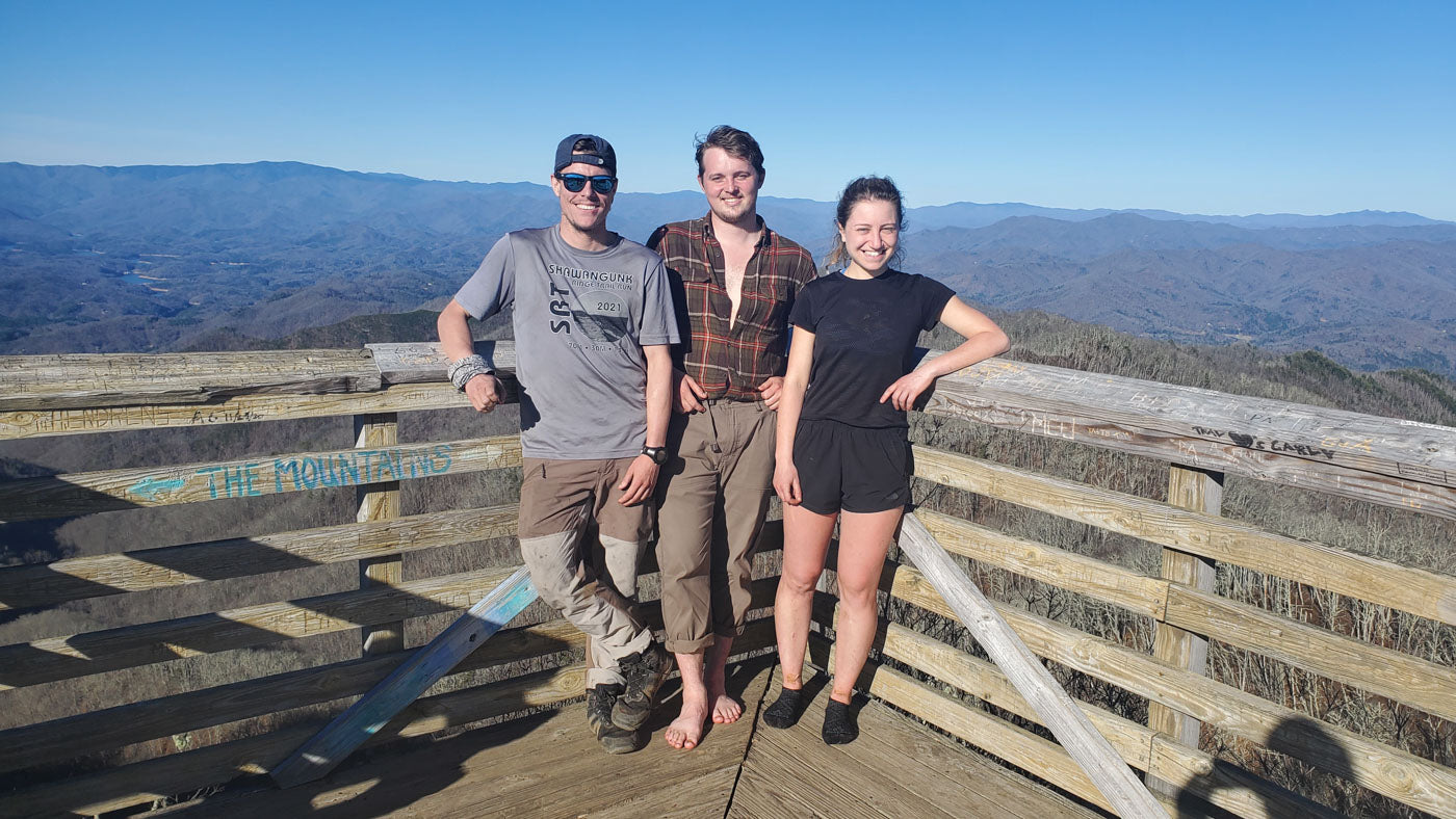 Three friends stand near an overlook on the Appalachian Trail.