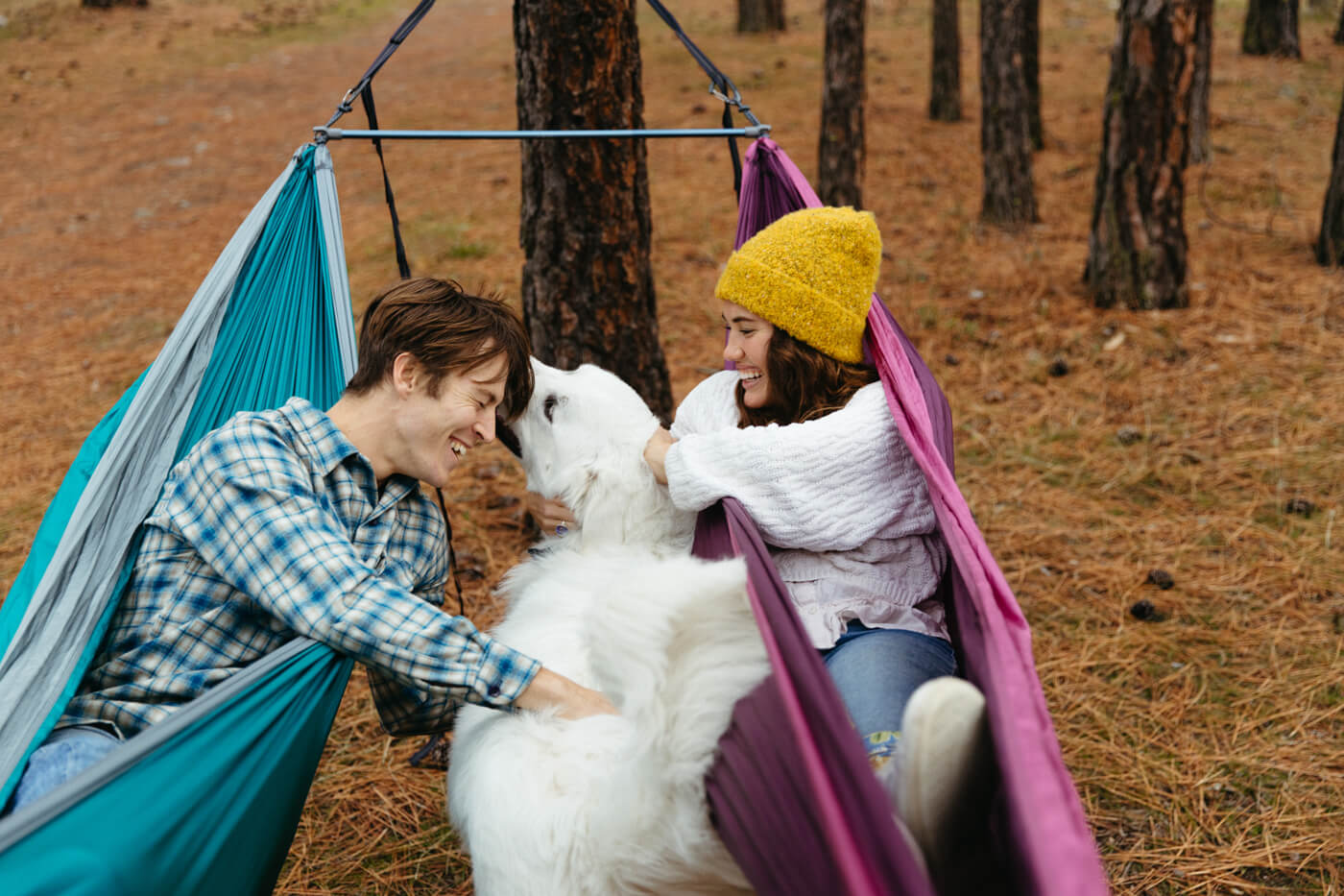 Two people hammock using the Fuse Tandem Hammock System while cuddling a dog. 