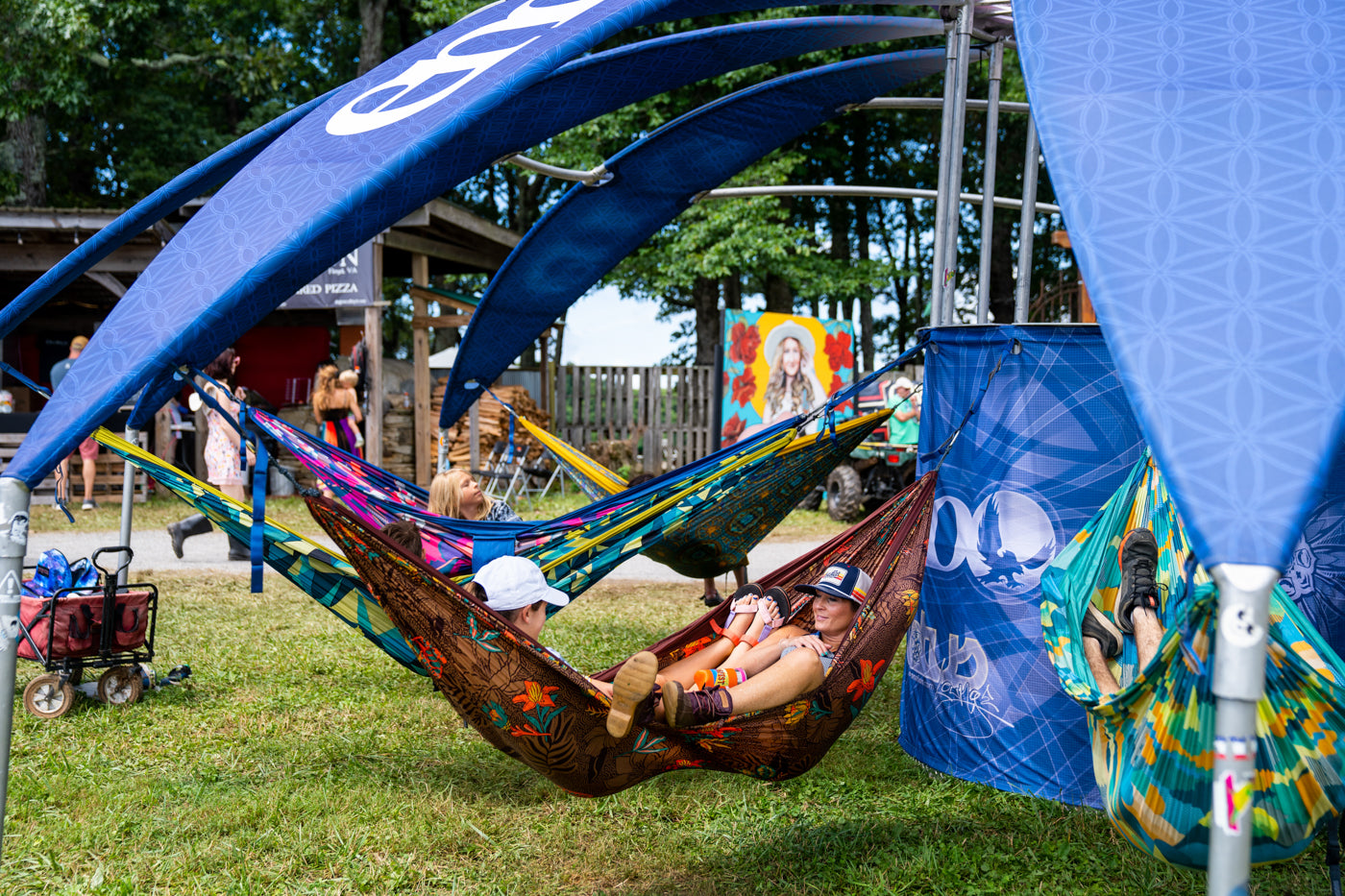 Two people share a DoubleNest Hammock Print in the Lotus Lounge while at Floyd Music Festival. 