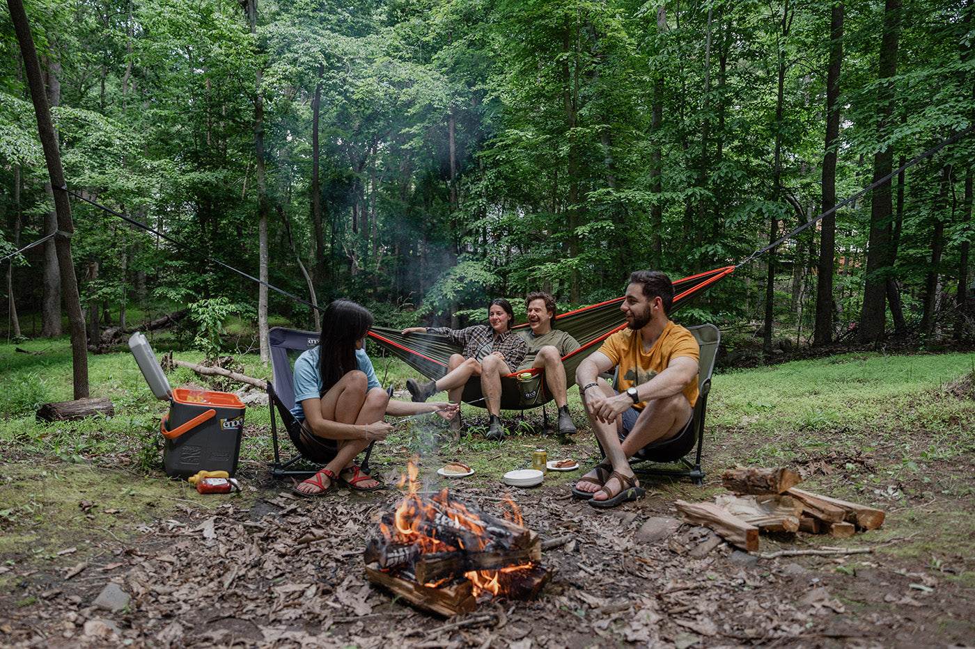 A group hangs around the fire while camping