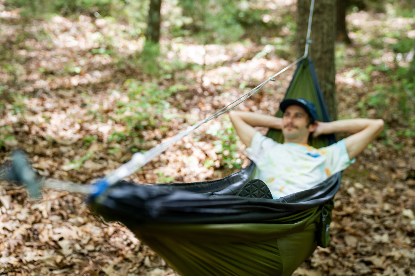 A man lays in a hammock using the Microtune Structural Ridgeline