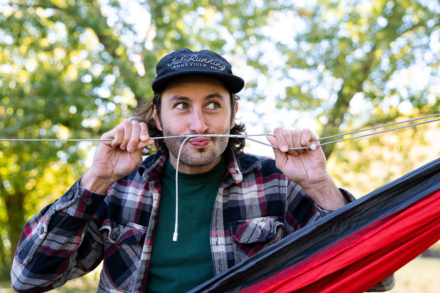 A man playfully uses the Microtune Structural Ridgeline to create a fake mustache on his face. 