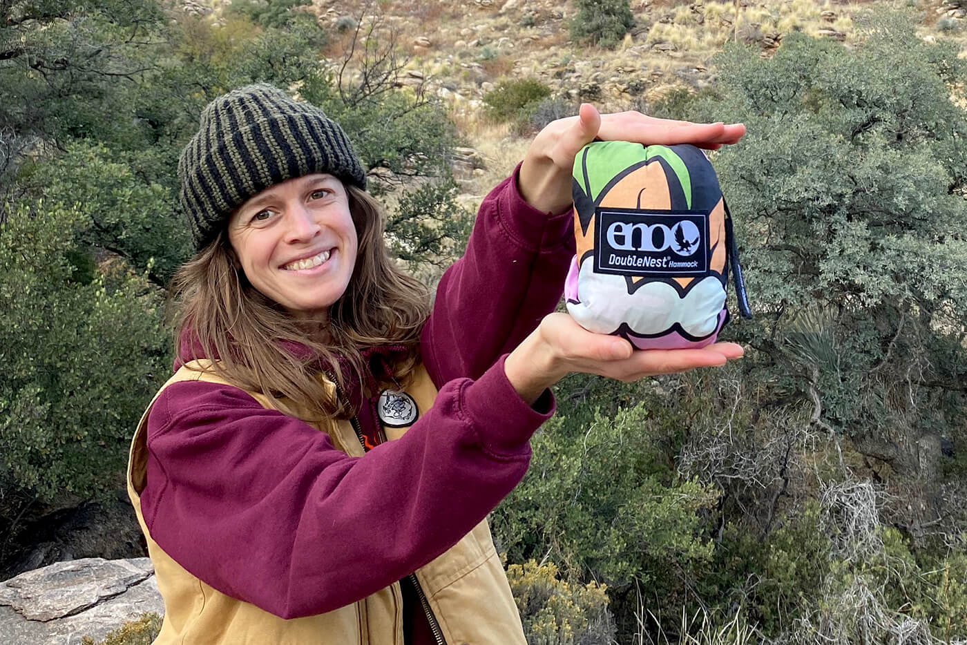 Hannah Eddy holds the Nature Talk hammock stuff sack in her hands as she smiles at the camera.