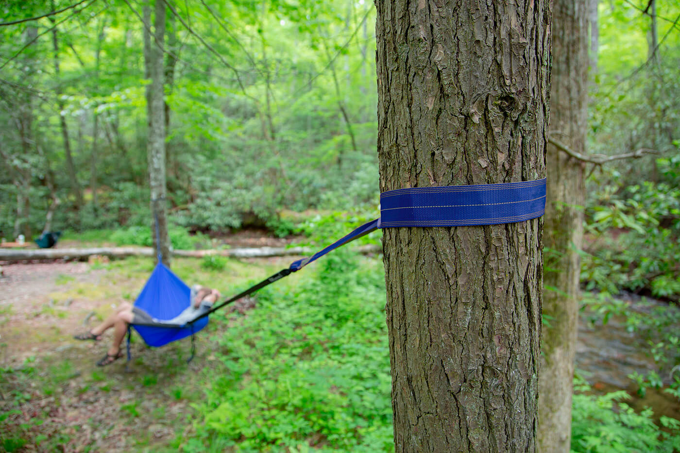 A person hammocks using Atlas EXT to extend their hammock length. 