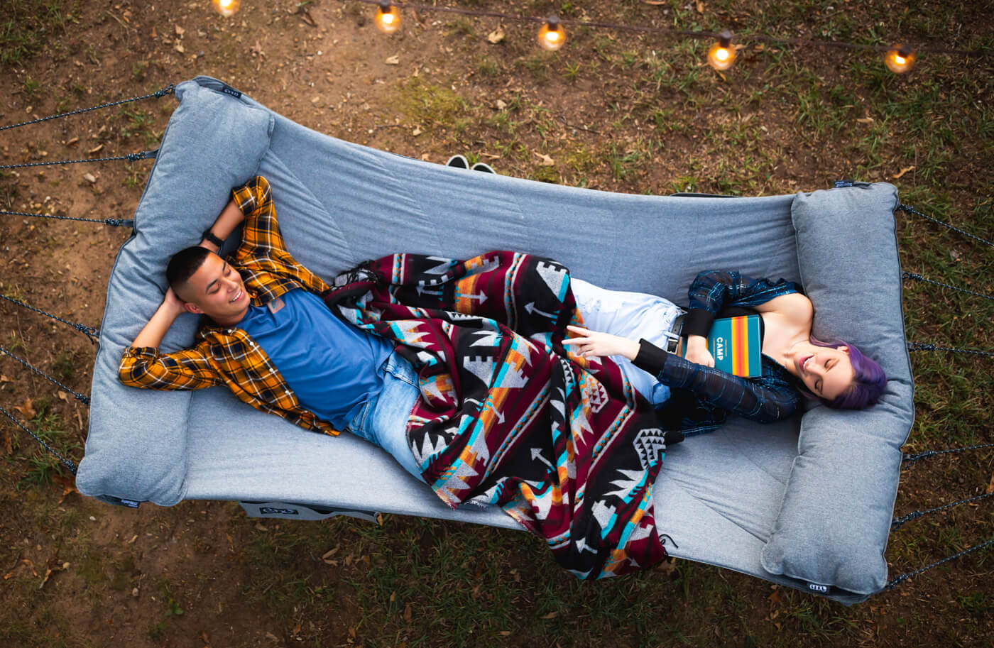 Two people share an ENO SuperNest Hammock while in their backyard.