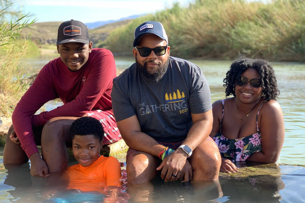 A family poses for a photo while swimming in a lake