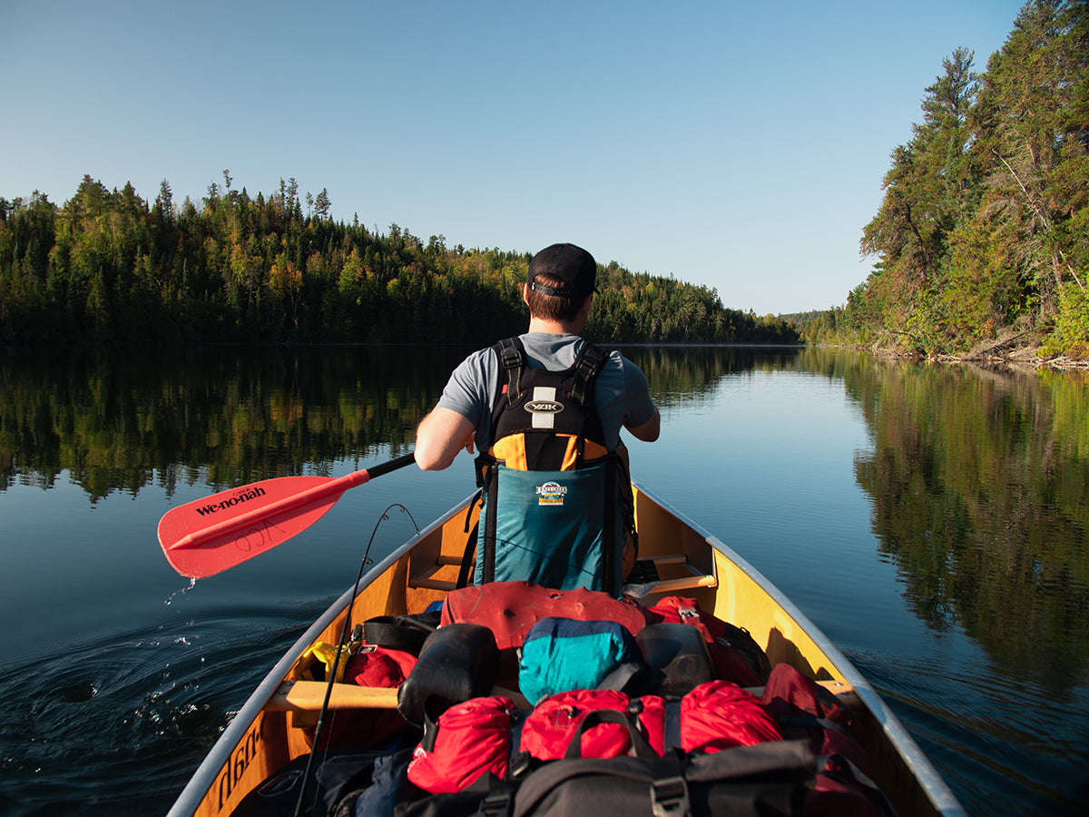 A man paddles in a canoe while in the Boundary Waters Canoe Wilderness