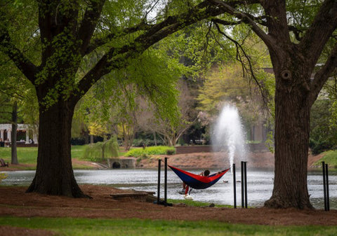 A student sits in a hammock at Elon University's Hammock Station